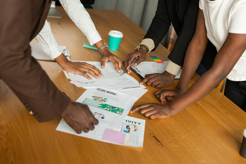 A diverse group of professionals actively discussing documents and collaborating on a project.